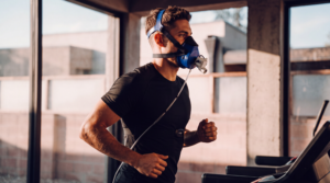 Client completing an active metabolic testing protocol on a treadmill with PNOE's breath analysis mask
